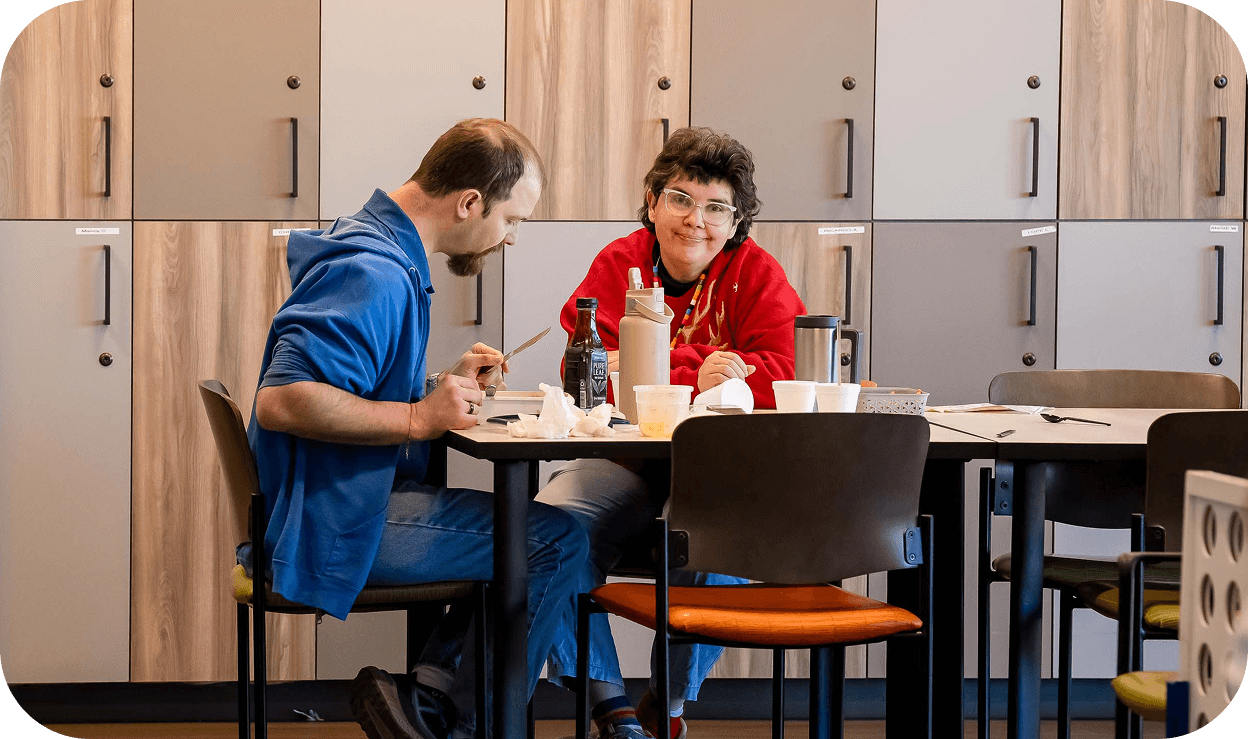 Two adults sitting at a table eating lunch together