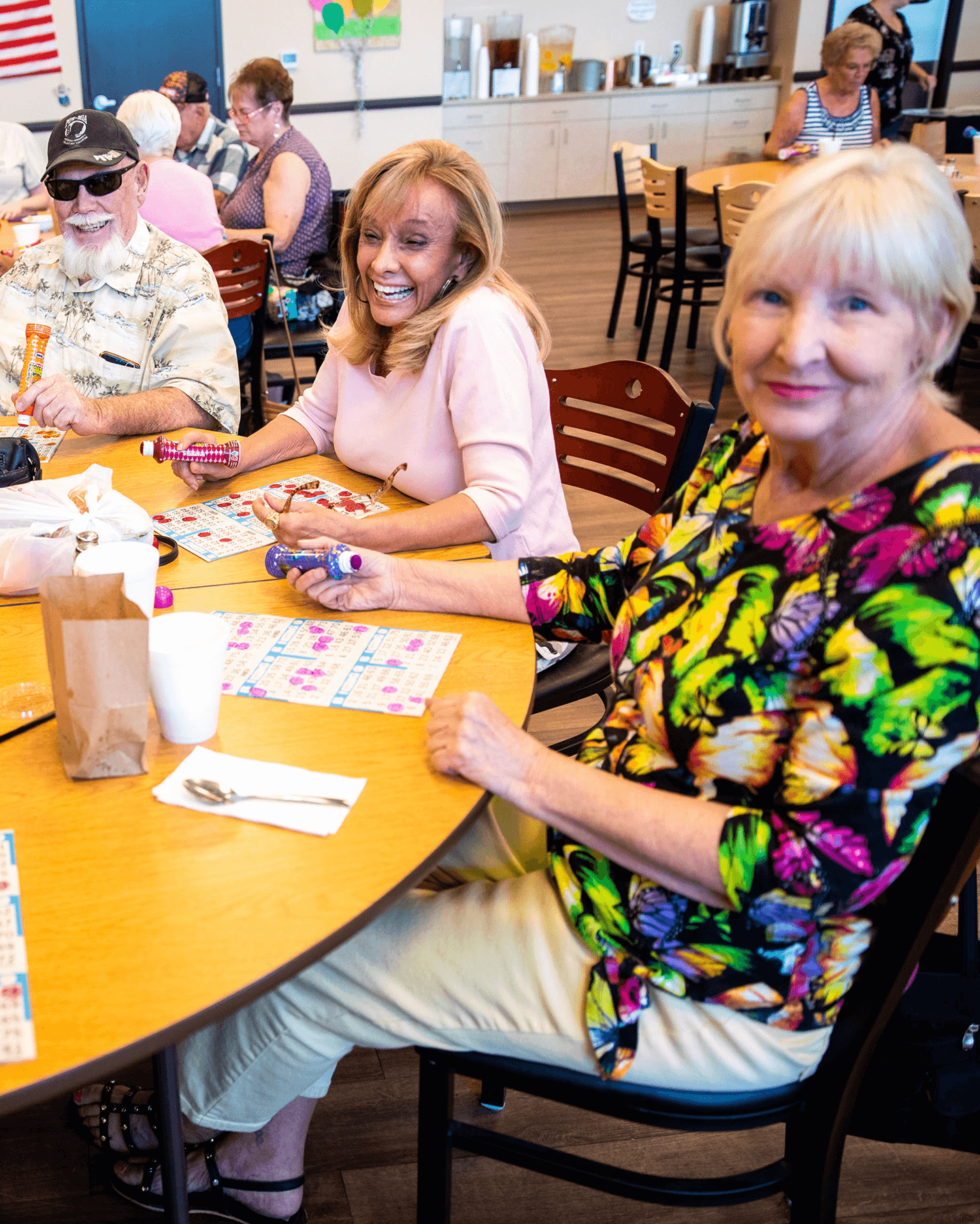 Two mature ladies sitting at a table playing bingo