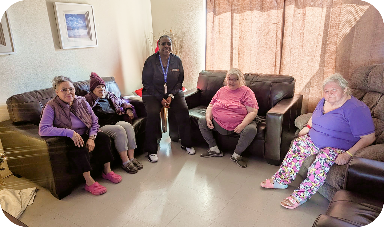 A group of elderly individuals sitting in a circle between a few sofa
