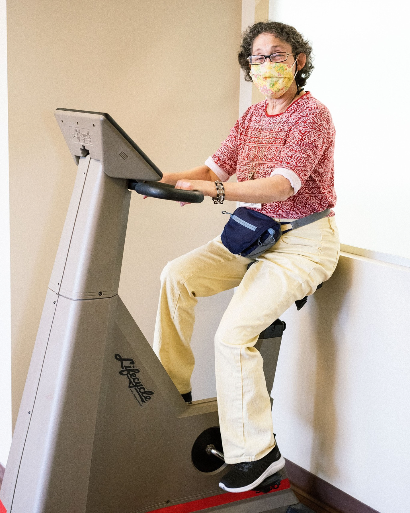 An elderly woman on a cycling machine