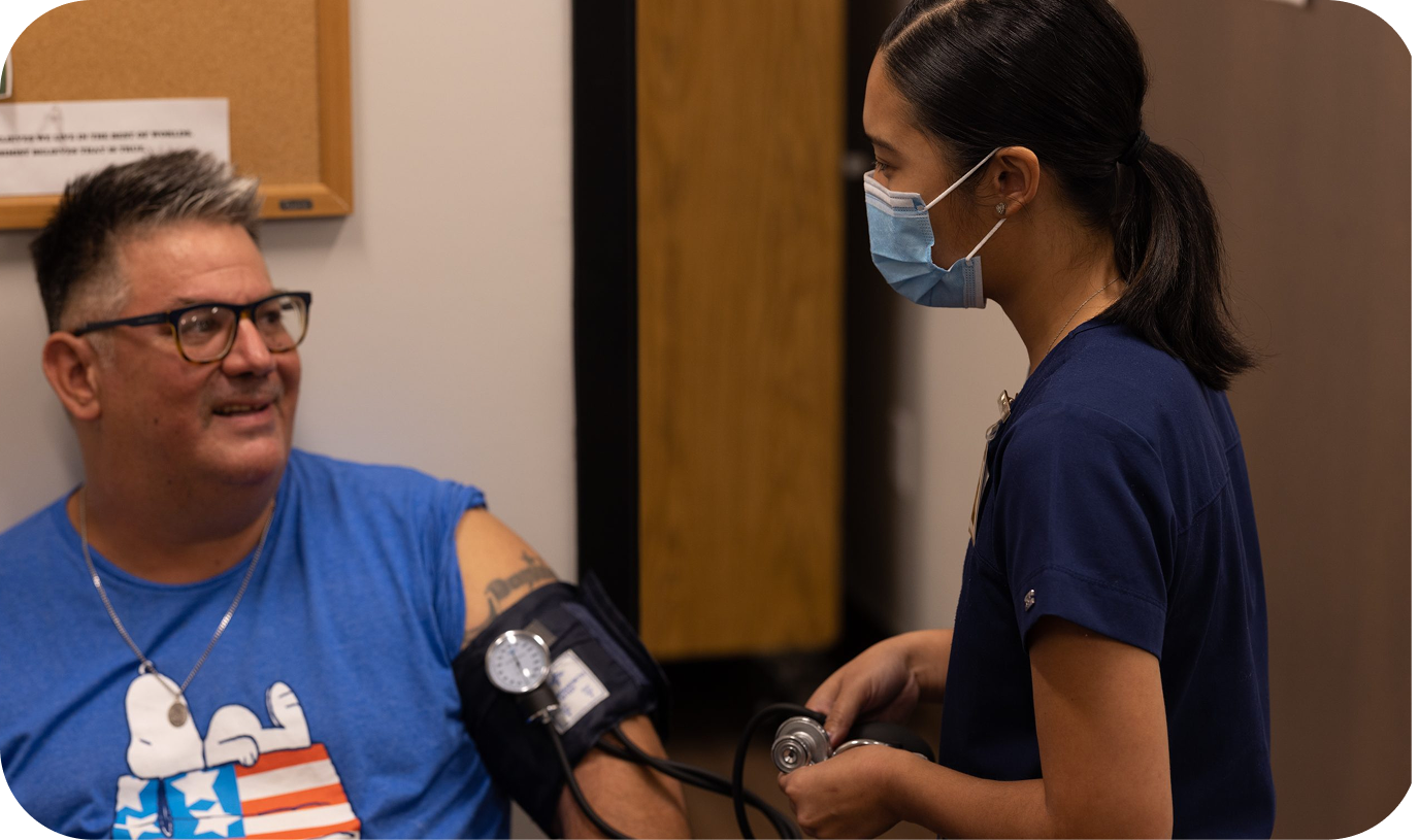 A nurse checking a male patient's blood pressure