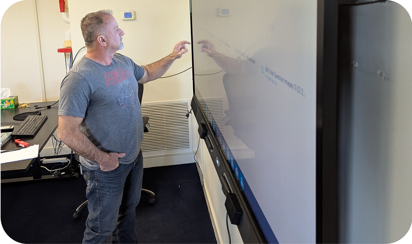 A male instructor using a smartboard in a classroom