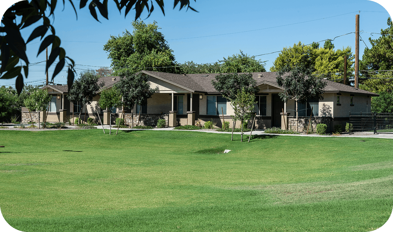 apartment complex with a green grass field in the front yard